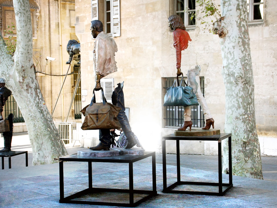 Sculptures of people with bags on display