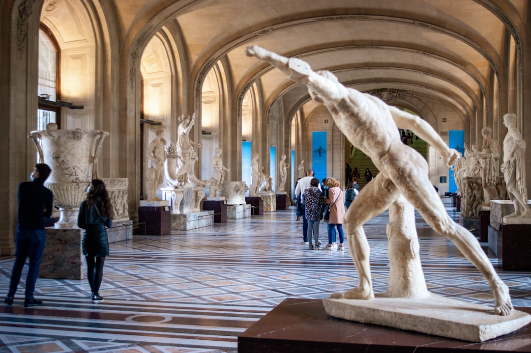 a group of people standing around a statue of a man