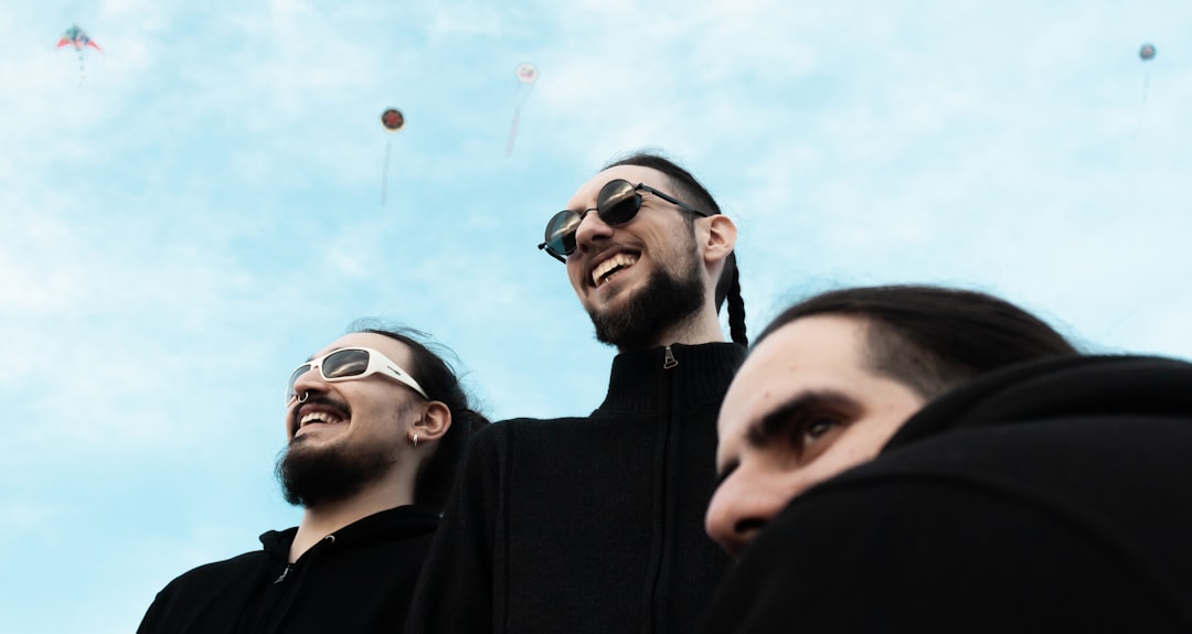 man in black hoodie wearing sunglasses beside man in black jacket